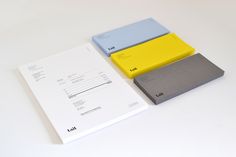 three different colored folders sitting next to each other on top of a white table