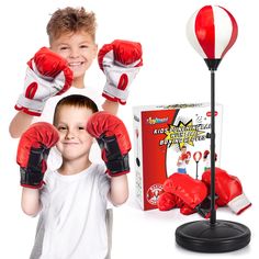 a young boy wearing boxing gloves and standing next to a stand with two boxing gloves on it