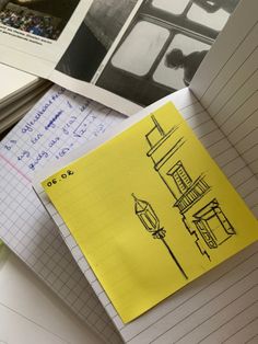 a yellow piece of paper sitting on top of a pile of notebooks and papers