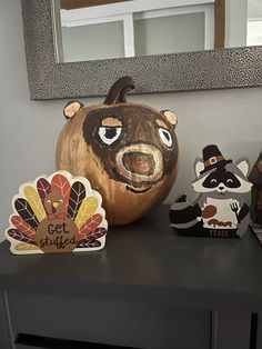 a table topped with wooden animals and a carved pumpkin