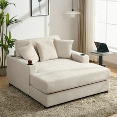 a white couch sitting on top of a rug in a living room next to a window