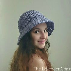 a woman wearing a blue crochet hat with long hair and smiling at the camera