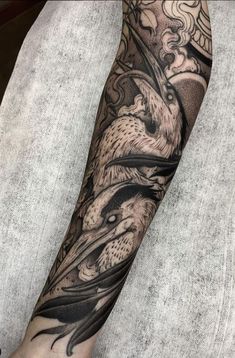 a man's arm with tattoos on it and an eagle in the middle of his arm