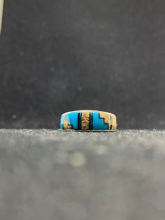 Contemporary handmade Native American Navajo inlay Jasper, sleeping beauty turquoise & Jet inlay ring sterling silver mens band ring Size 11 by A.T This ring is made with the famous Zuni style; Inlay Inlay is the process of hand-cutting each stone to fit in a flush surface. As you can see, the stones are also slightly raised to give it a textured feeling. There are 33 hand cut stones soldered and inlayed into a silver bezel with gorgeous silver work surrounding the stones. Nice thick silver. Wei Mens Band Rings, Sleeping Beauty Turquoise, Silver Work, Picture Jasper, Mens Band, Sterling Silver Mens, Band Ring, Nativity, Band Rings