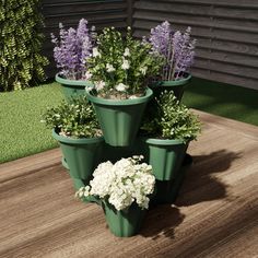 a group of potted plants sitting on top of a wooden table next to grass