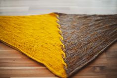 a yellow and brown rug on top of a wooden floor