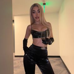 a woman in latex holding a wine glass and posing for the camera with her hands on her hips