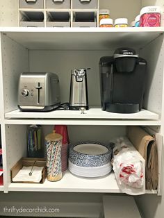 an organized pantry with coffee maker, toaster and other kitchen items on the shelves