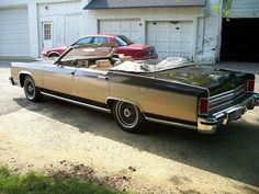 an old car parked in front of a garage