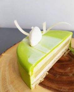 a slice of green cake sitting on top of a wooden plate