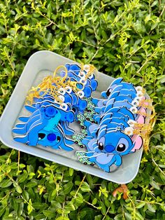 a tray with some blue and yellow items on top of green leaves in the grass