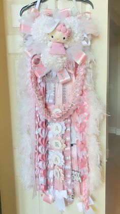 a door hanger decorated with pink and white items