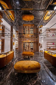 the interior of a store with marble flooring and gold accents on the walls, along with wooden shelves