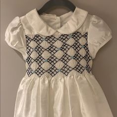 Beautiful Traditional Silk (Look)White Smocked (Navy & Light Blue Embroidered Rose Detail) Dress With Tie Back Lined New Without Tags Size 3/3t 100%Polyester Short Sleeve Smocked Dress For Baptism, Baptism Smocked Dress With Short Sleeves, Baptism Short Sleeve Smocked Dress, White Smocked Dress With Short Sleeves, Smocking Frocks, White Smocked Dress, Smocking Plates, Smocking Patterns, Toddler Dresses