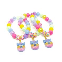 These adorable stretchy bracelets are the perfect favor for your little one's unicorn donut themed party! Each bracelet features a glittery rainbow unicorn donut charm, resin rhinestone beads and an assortment of pink, purple, blue, green and yellow 10mm acrylic beads strung with durable stretch floss cord. Each bracelet will arrive individually packaged in organza bags. Select the size and number of bracelets needed from the drop down menus. Please message me if you have any questions or if you Novelty Multicolor Jewelry For Birthday, Pink Beaded Jewelry For Party Favors, Rainbow Novelty Jewelry For Birthday, Novelty Multicolor Charm Bracelet For Birthday, Adjustable Purple Charm Bracelet For Birthday, Multicolor Novelty Party Supplies For Gifts, Playful Beaded Charm Bracelet For Birthday, Cute Round Beads Jewelry For Party Favors, Novelty Beaded Bracelets For Birthday