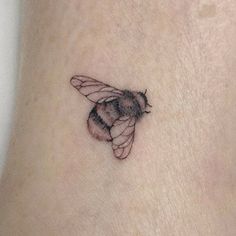 a small bee tattoo on the ankle