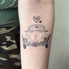 a small tattoo on the arm of a woman with a car and flowers in it