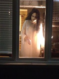 a creepy doll is standing in the window