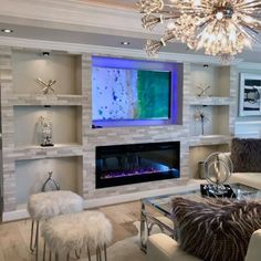 a living room with white furniture and a large tv mounted on the wall above it