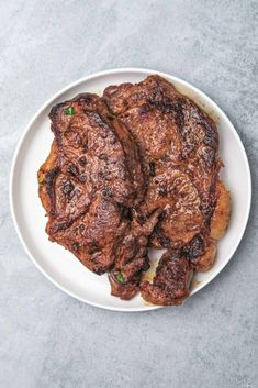 two pieces of steak on a white plate