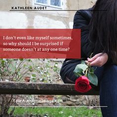 a woman sitting on a bench holding a rose