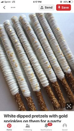 four sticks with white frosting and gold sprinkles are lined up in a row