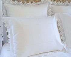 four pillows with white lace trim on them