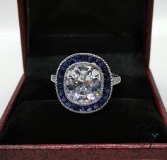 a diamond and blue sapphire ring in a box