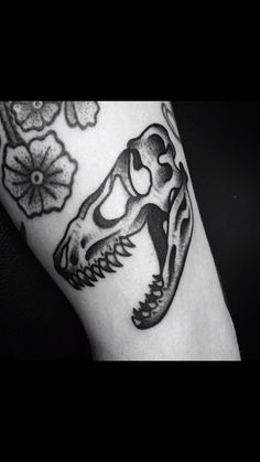 a black and white photo of a tattoo design on the arm, with flowers in the background