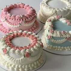 there are four cakes that have pink and blue frosting on them