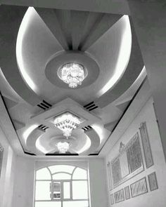 an empty room with chandeliers and pictures on the wall in black and white