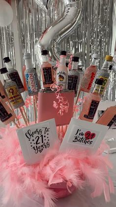 a pink centerpiece filled with bottles and decorations