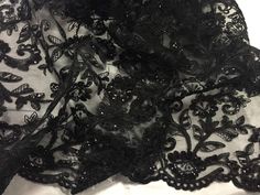 black lace fabric with flowers and butterflies on it