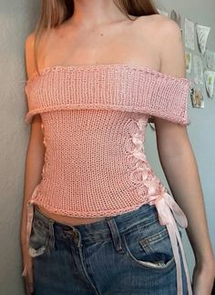 a woman wearing a pink top and jeans