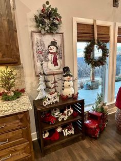 a kitchen decorated for christmas with snowmen and wreaths