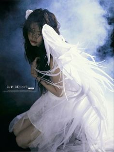 a woman dressed in white is posing for a photo with feathers on her head and body