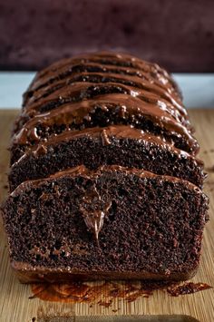 a loaf of chocolate cake sitting on top of a wooden cutting board