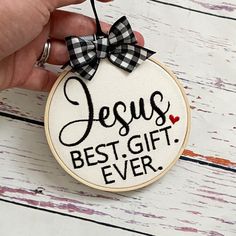 a hand holding a cross stitch ornament with the words jesus best gift ever