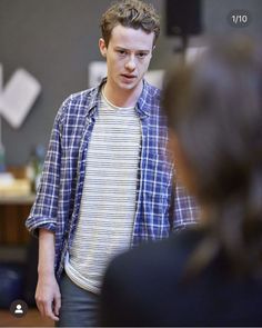 a young man standing in front of a group of people