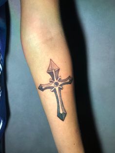 a person with a cross tattoo on their arm