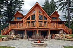 a large wooden house sitting on top of a lush green field