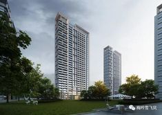 two tall buildings sitting next to each other on top of a lush green field in front of trees