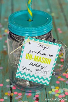 a mason jar with a birthday card and a straw sticking out of it, on top of confetti