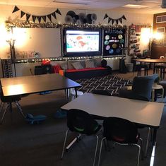 a classroom with tables, chairs and a flat screen tv