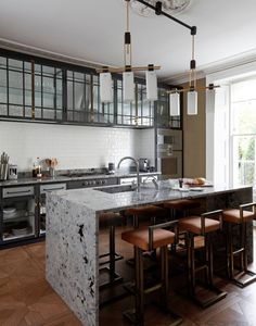 a kitchen with marble counter tops and wooden stools