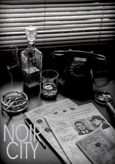 a table topped with glasses and papers next to a bottle