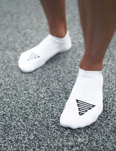 a close up of a person wearing white socks with black triangles on the bottom of them