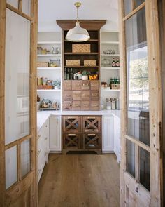 an open kitchen with wooden cabinets and white cupboards on either side of the door