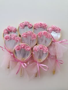 pink roses are arranged in the shape of heart shaped cookies with tulle and bows