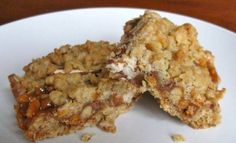 two oatmeal bars on a white plate with one broken in the middle